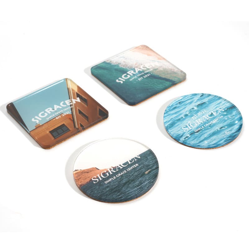 Acrylic coasters set featuring a mix of square and round designs in blue and earthy tones, each with unique imagery and branding. Acrylic Cork Coasters Set - Image 1