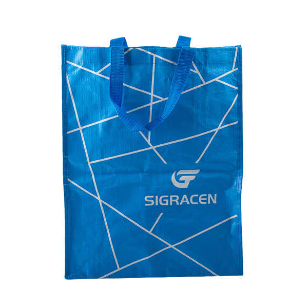 A blue reusable woven plastic waterproof tote bag with geometric patterns and handles, featuring a logo. Reusable Woven Plastic Waterproof Tote Bag - Image 1