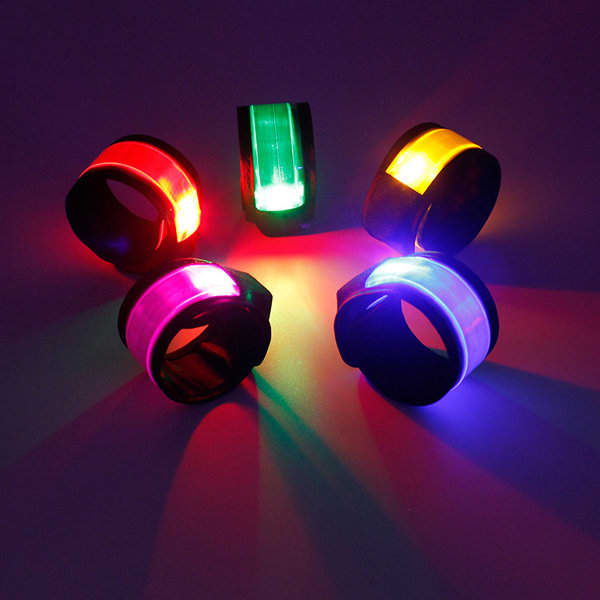 Brightly coloured slap bracelets with LED lights, displayed against a dark background. Various colours are visible. Custom Light Up Sport Slap Bracelet - Image 1