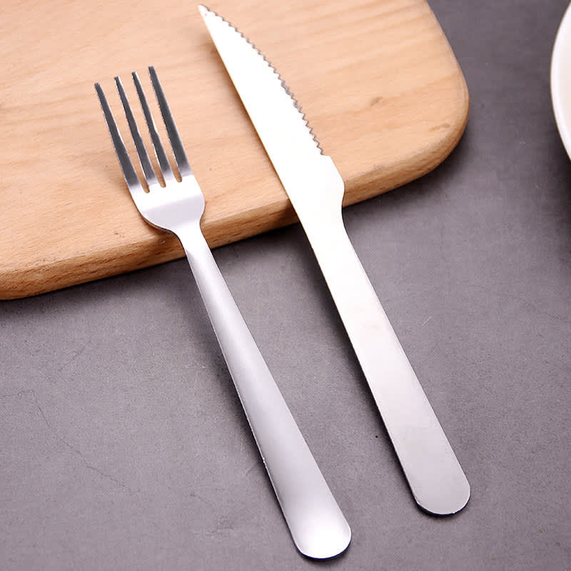 A stainless steel cutlery set featuring a fork and a knife, resting on a wooden surface. Stainless Steel Cutlery Set - Image 1