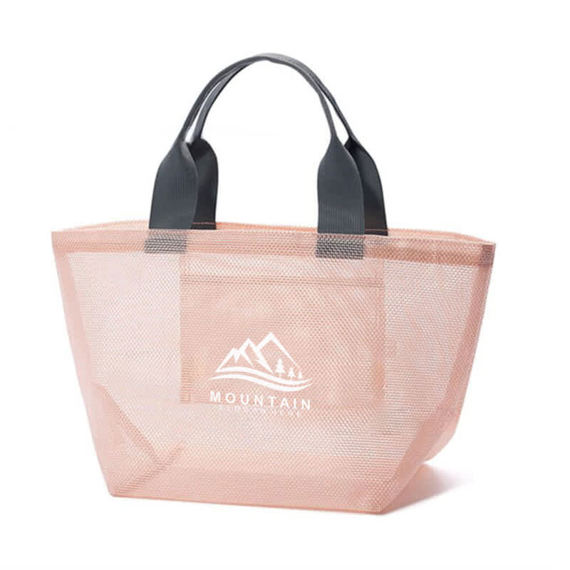A foldable mesh tote bag in a soft pink hue with grey handles and a logo featuring mountains. Foldable Mesh Beach Tote Bag - Image 1