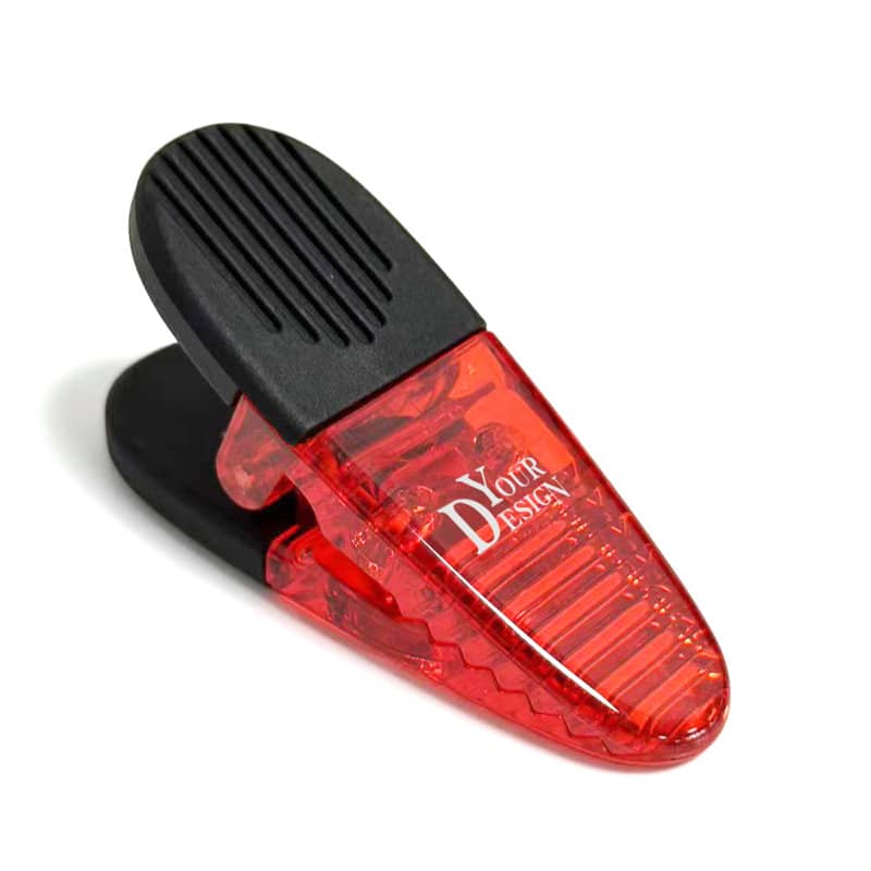 A red and black oval plastic magnetic clip featuring a design area and a textured gripping surface. Oval Plastic Magnetic Clip - Image 1