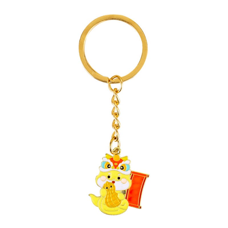 A yellow metal keychain featuring a decorative lion design and a small scroll, attached to a gold keyring. Custom Metal Keychain - Image 1